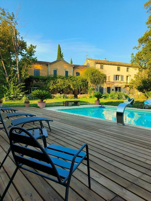une paire de bancs assis sur une terrasse près d'une piscine dans l'établissement La villa des figuiers, à Saint-Bonnet-du-Gard