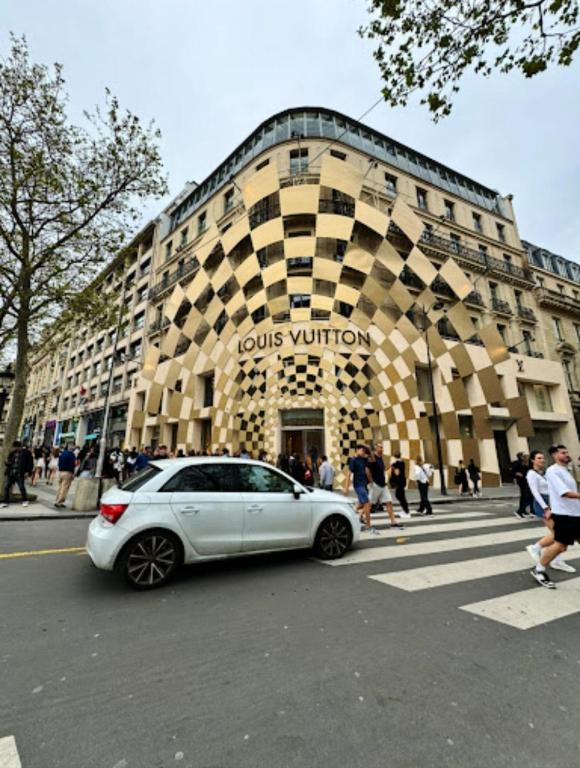 une voiture blanche garée devant un immeuble dans l'établissement Luxury Loft Champs Élysée, à Paris