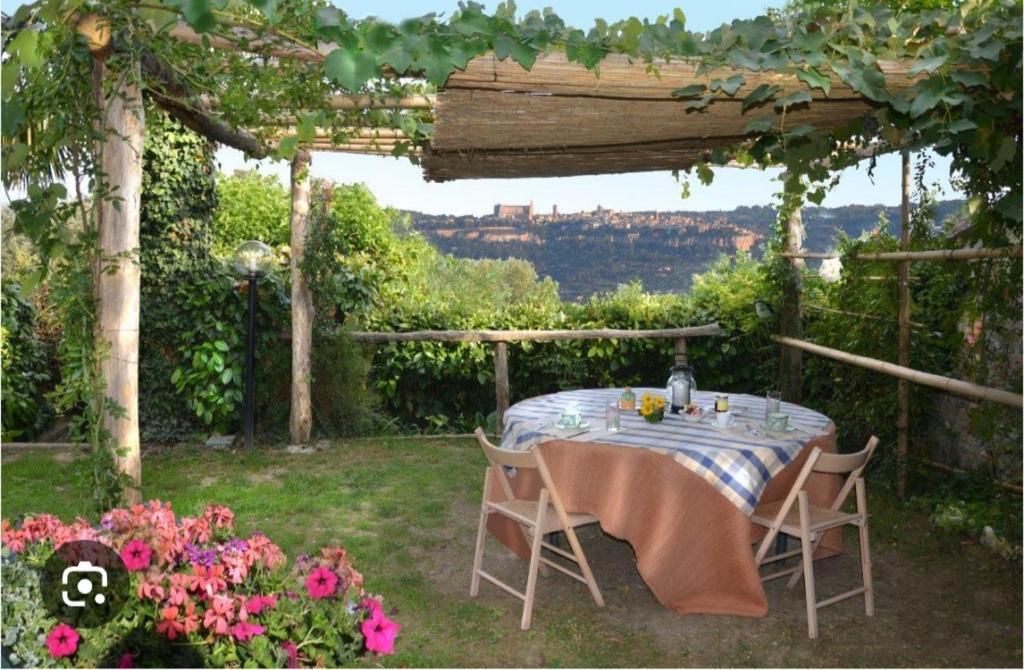 una mesa y sillas sentadas bajo una pérgola en Holiday House Sant'Annunziata, en Monte Rubiaglio