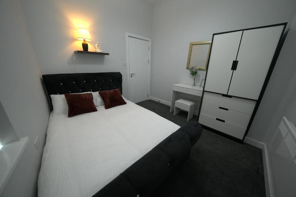 a bedroom with a bed and a dresser and a mirror at Charming Oxford Apartment in Telford - Flat 1 in Telford