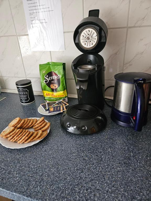 un comptoir avec une cafetière et une assiette de biscuits dans l'établissement Zimmervermietung Freiberg Zentrum, à Freiberg