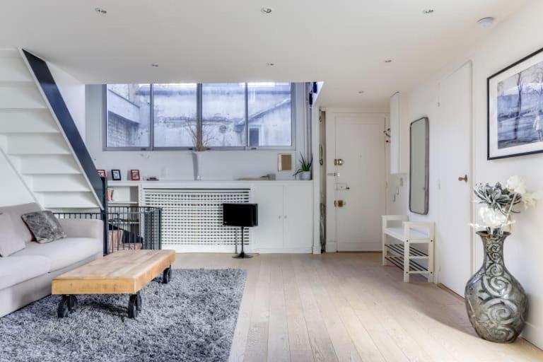 un salon avec un canapé et une table dans l'établissement Appartement d'Artiste, Terrasse Vue Tour Eiffel, à Paris