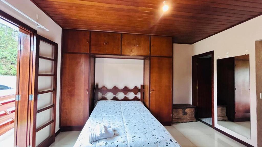 a bedroom with a bed with a wooden ceiling at Casa na serra in Campos do Jordão