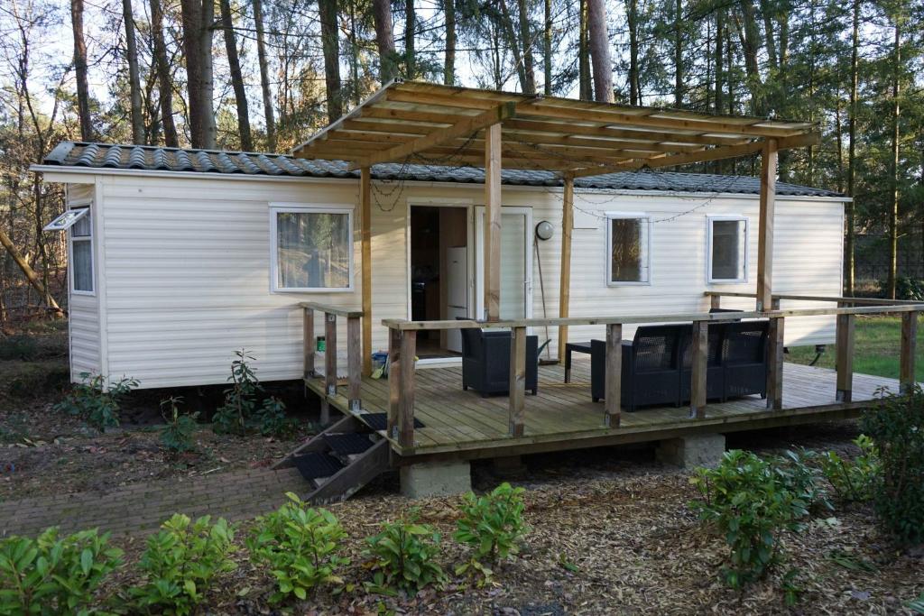 a tiny house with a porch and a deck at Kota Kiva in Hulshorst