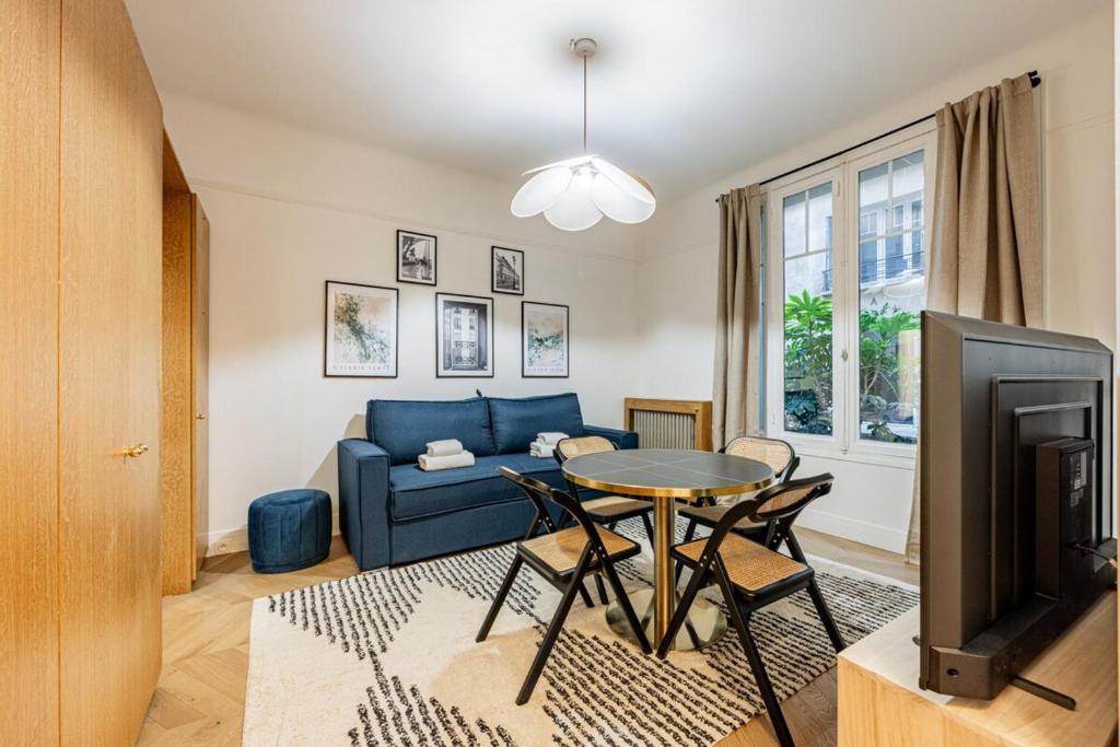un salon avec un canapé bleu et une table dans l'établissement Elegant 1BR - Muette - Auteuil, à Paris