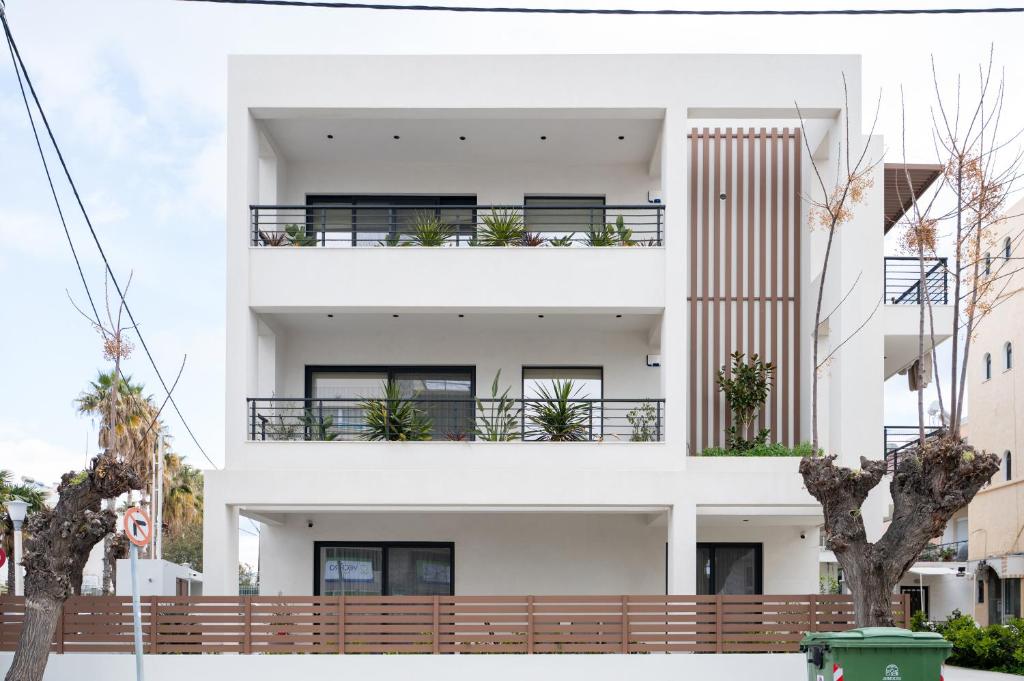 a white building with balconies and trees at Callas Home in Kos