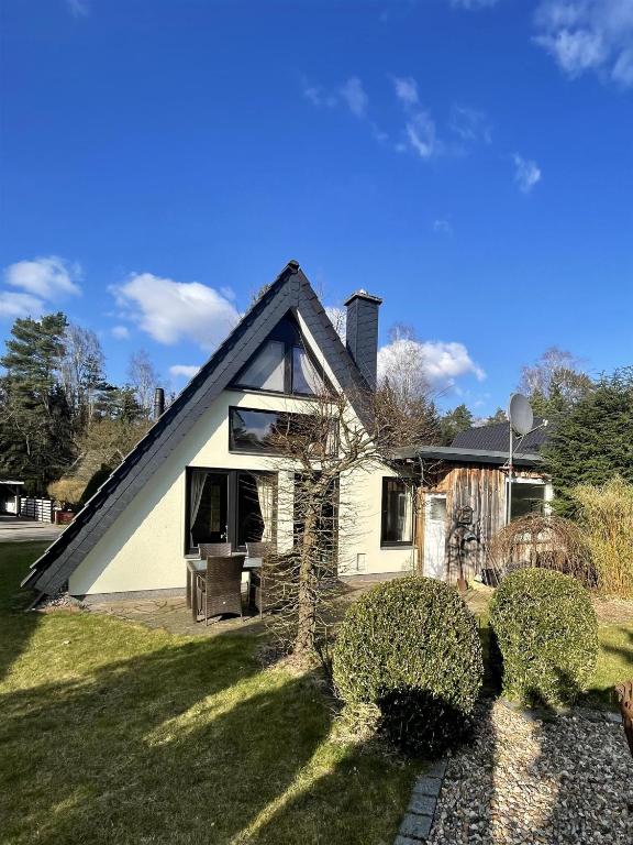 a white house with a black gambrel roof at Goorn Hus, Ferienhaus in Schneverdingen
