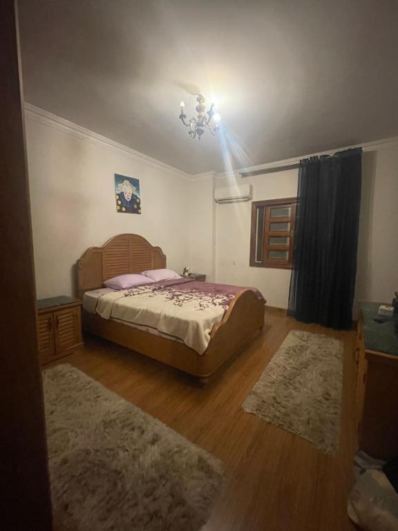 Un dormitorio con una cama y una lámpara de araña. en Zayed Villa, en Sheikh Zayed