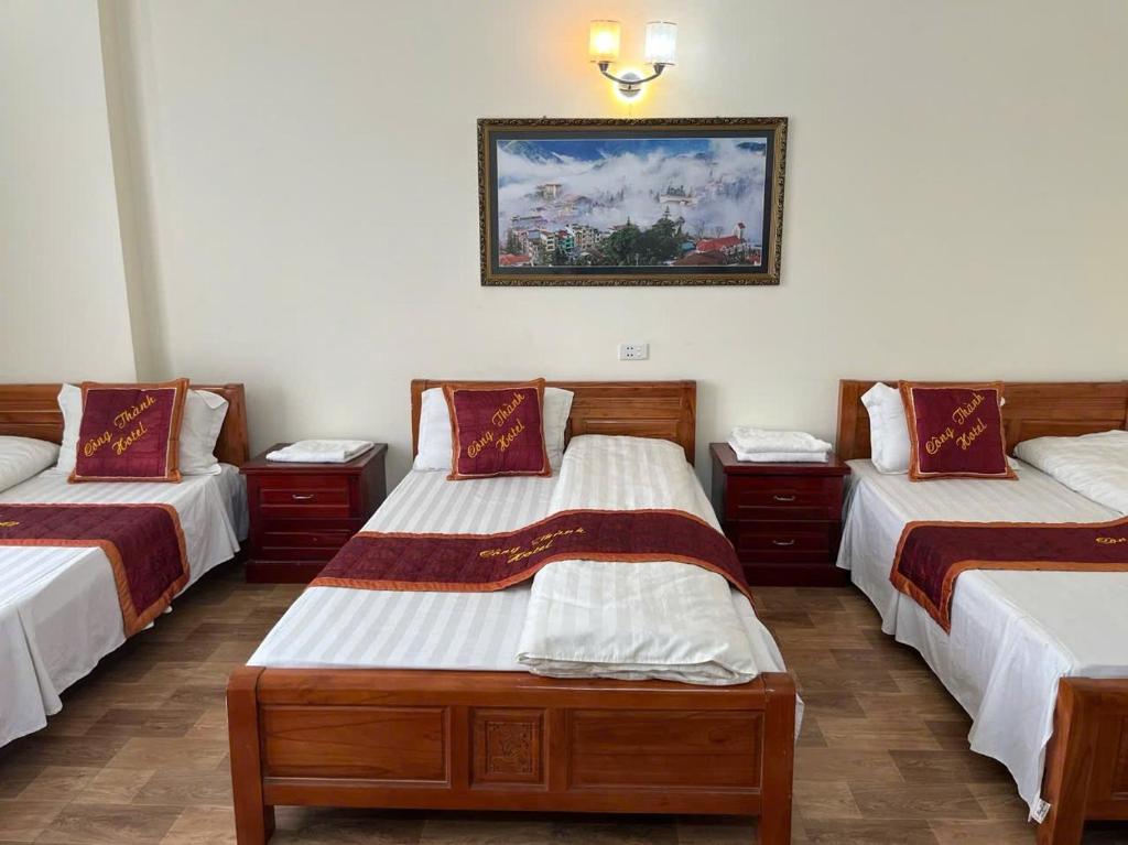 a room with three beds and a picture on the wall at Công Thành hotel in Lao Cai