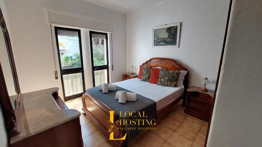 a bedroom with a bed and two windows at Golden Algarve Apartament By Localhosting in Albufeira