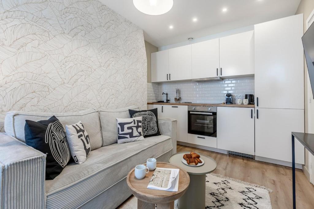 un salon avec un canapé et une cuisine dans l'établissement A31#Republique # 1BedRoom # Marais # Paris03 # AC, à Paris