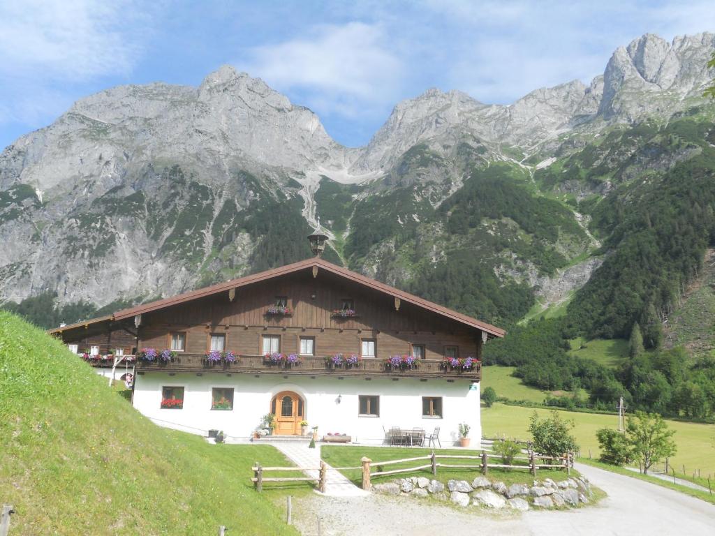 a house on a hill with mountains in the background at Vorderhof in Sankt Martin am Tennengebirge