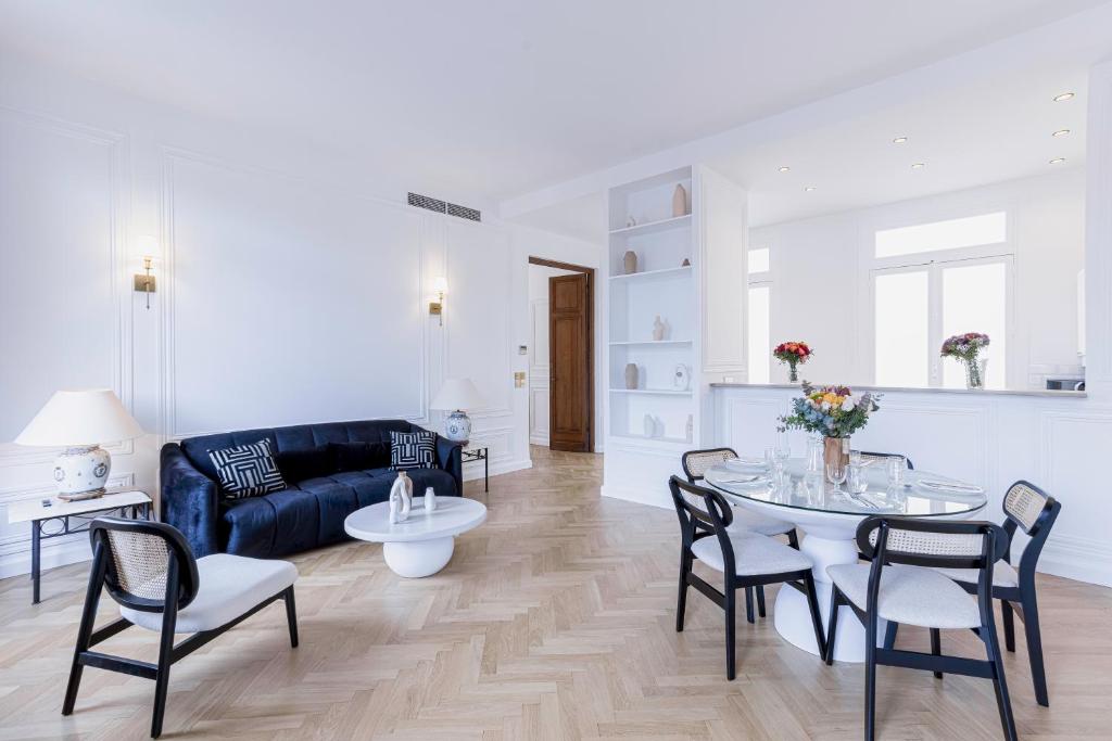 un salon avec un canapé, une table et des chaises dans l'établissement Le Suite Napoléon - Luxe et Sérénité au Cœur de Cannes, à Cannes