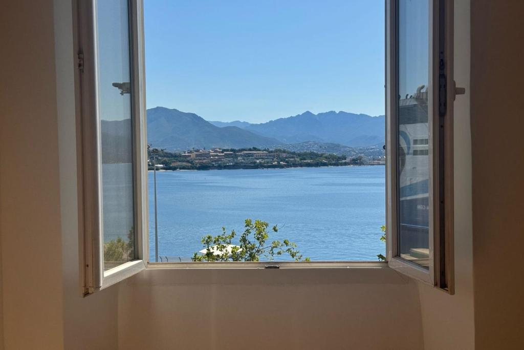 une fenêtre ouverte avec vue sur l'eau dans l'établissement Laure - Luminous Cozy Sampiero - by TGB, à Ajaccio