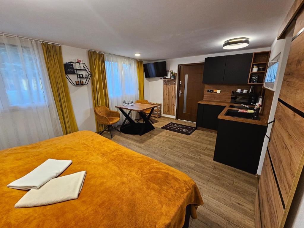 a hotel room with a large bed and a kitchen at Apartmány Lenka Bešeňová 104 in Bešeňová