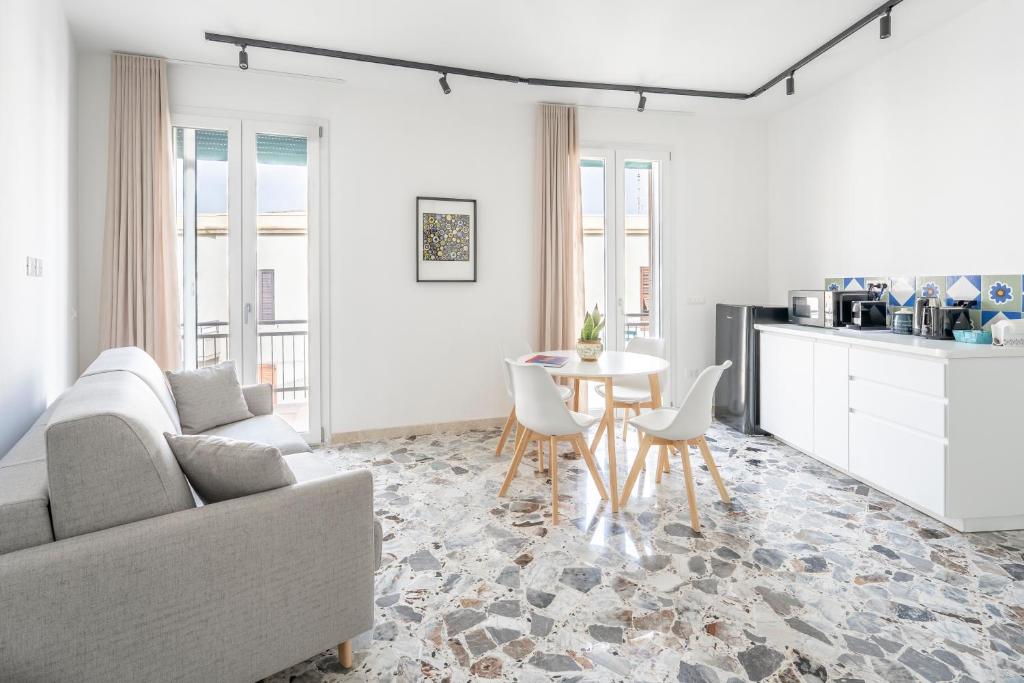 ein Wohnzimmer mit Sofa und Tisch in der Unterkunft Eos Serenity Suites in Syrakus