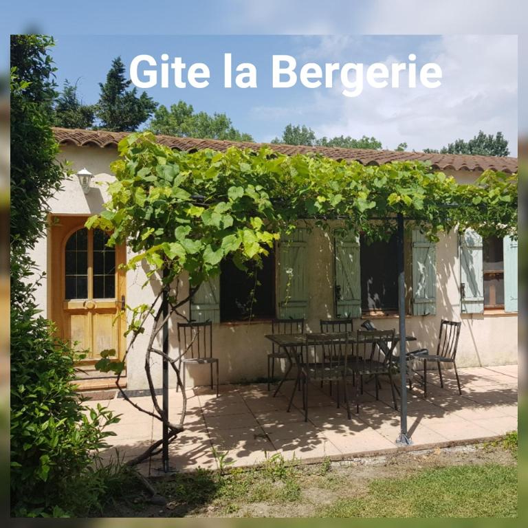 une pergola avec une table et des chaises devant une maison dans l'établissement Mas de Guinot, à Villeneuve