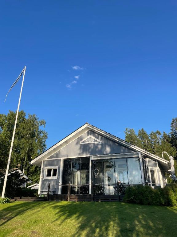 a house with glass windows in a yard at Rantahelmi-huvila in Eurajoki