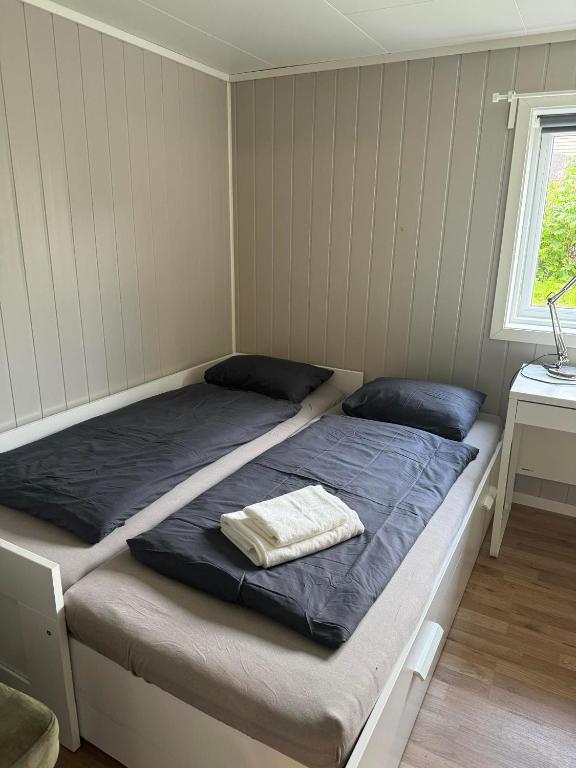 a bedroom with a bed with a blue blanket at Room with shared kitchen and bathroom nr 2 in Tromsø