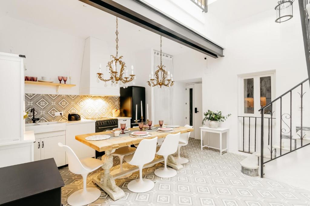 a kitchen with a wooden table and white chairs at Plaza España 5 Casa con encanto, terraza y vistas in Vejer de la Frontera