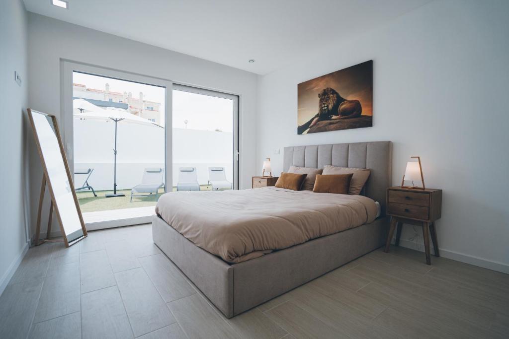 une chambre avec un grand lit et une grande fenêtre dans l'établissement Villa Paradise 2, à Mariquiteira