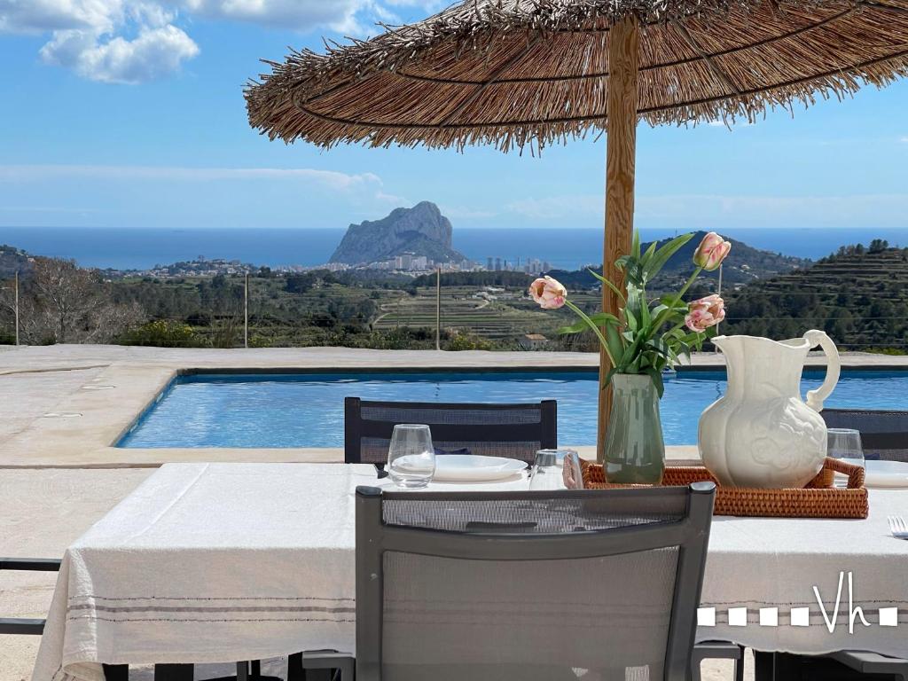 a table with a vase and a table with an umbrella at VH Costa Blanca - MATIMI in Benissa