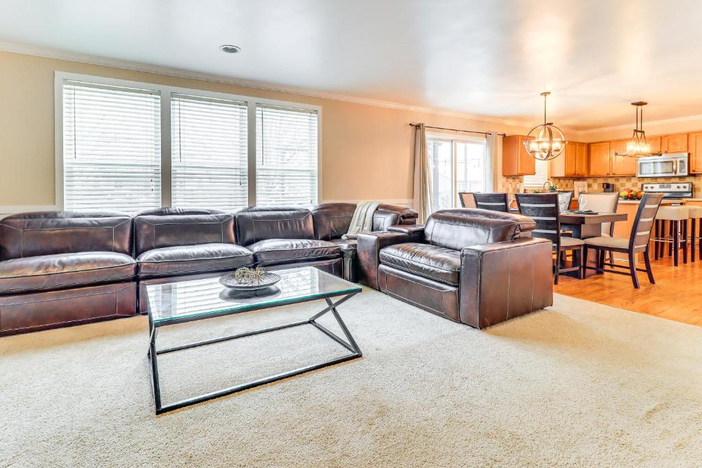 a living room with a leather couch and a table at 5 Mi to EMU Home with Seasonal Pool Access in Lincoln