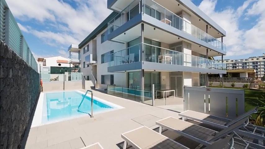 ein Apartmenthaus mit einem Pool und einem Gebäude in der Unterkunft El Yate in San Agustín