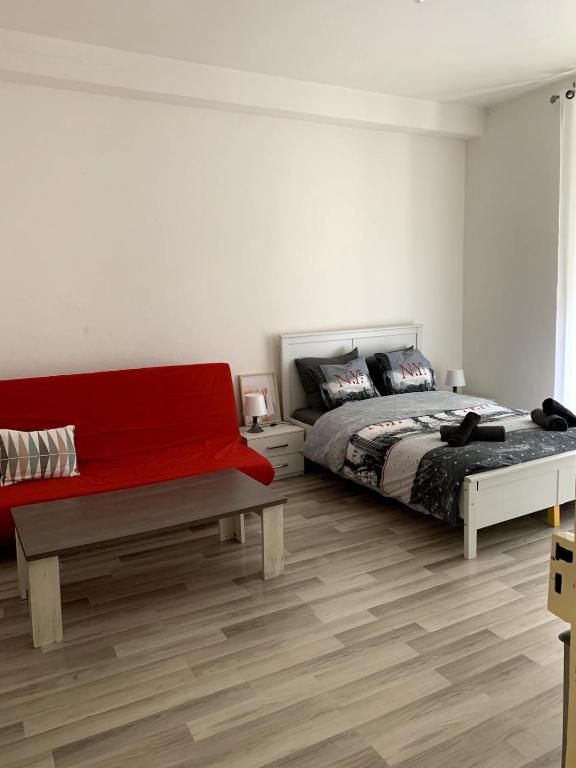 une chambre avec un lit et un banc dans l'établissement Grand appartement proche centre et tram, à Mulhouse
