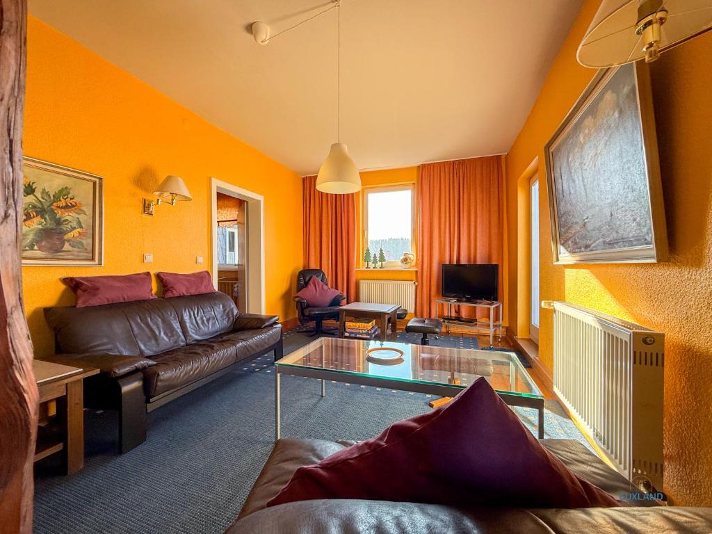 a living room with a couch and a glass table at Landhaus Stolper Wohnung 1 in Herzberg am Harz