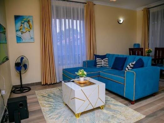 a living room with a blue couch and a table at Amazing apartment in Milimani Kisumu-Kabs in Kisumu