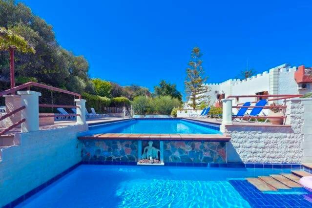 a swimming pool in a house with a blue at Thodorou Sunset Villa in Stalos