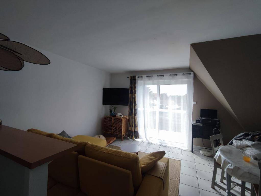 a living room with a couch and a window at la détente in Berck-sur-Mer