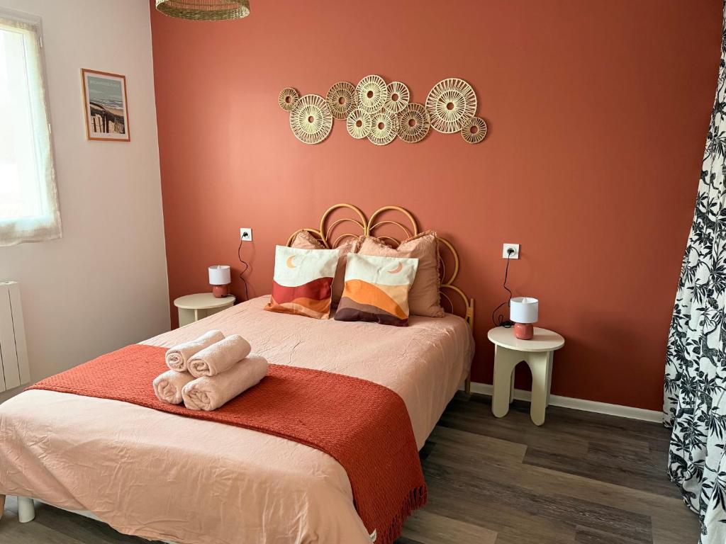 a bedroom with a large bed with orange walls at Appartement Cosy avec Balcon in Parentis-en-Born