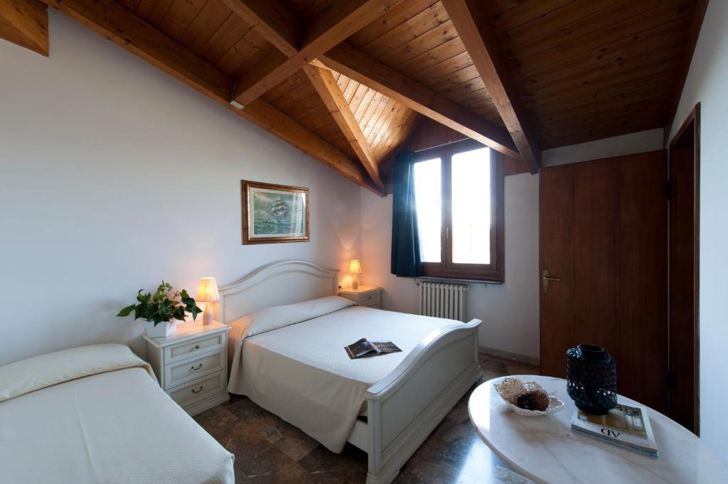 a bedroom with a white bed and a window at Hotel Caselle in San Lazzaro di Savena