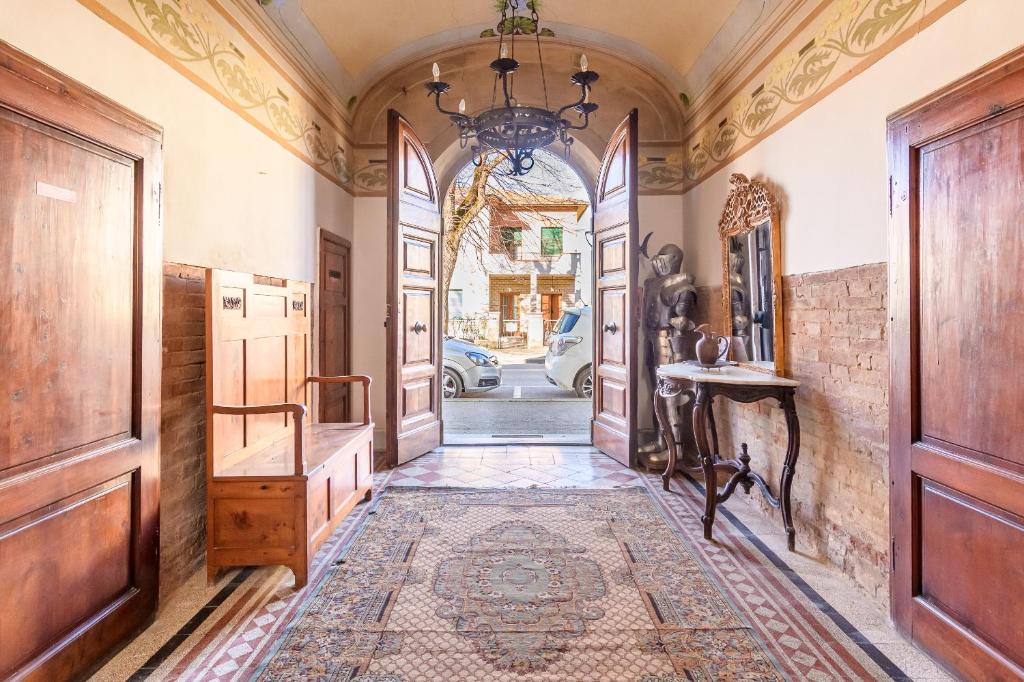 an ornate hallway with a door and a table at Appartamenti Villa Letizia in Foiano della Chiana