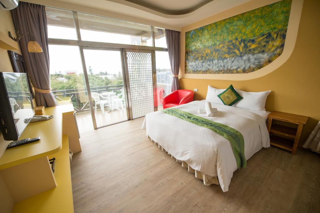 墾丁的住宿－頂佳旅棧，酒店客房设有一张床和一个阳台。