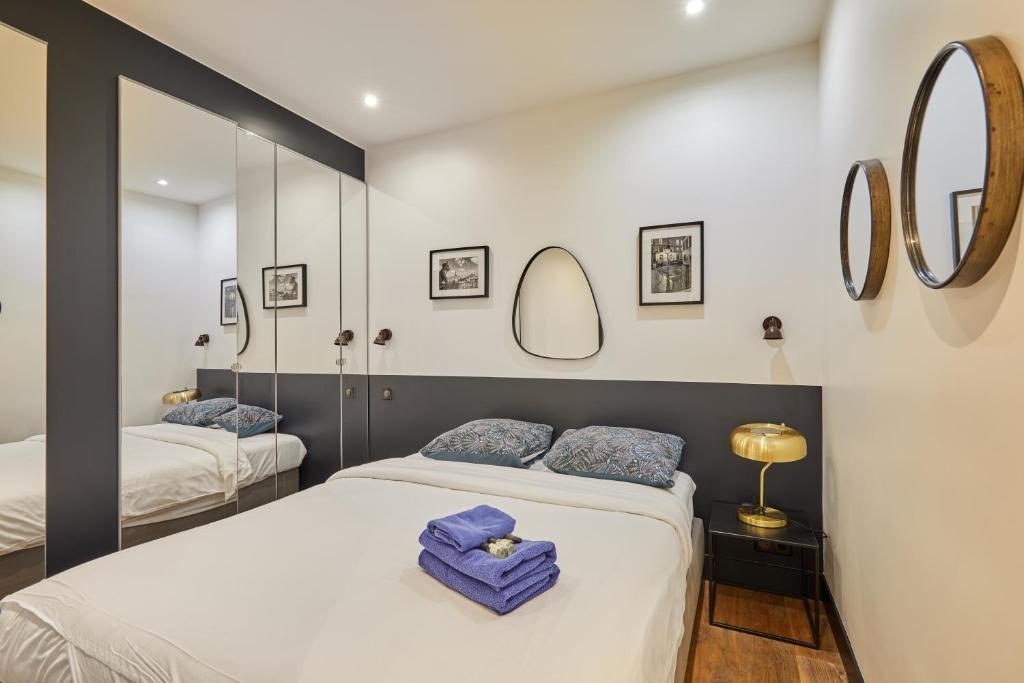 - une chambre avec 2 lits et 2 miroirs dans l'établissement Rent a Room apartments - Alma, à Paris