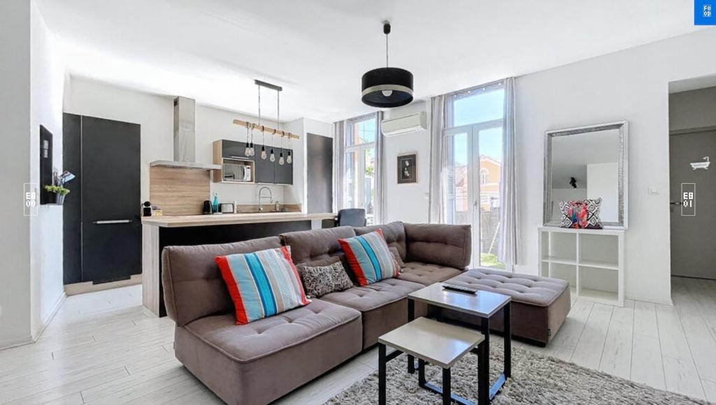 un salon avec un canapé marron et une cuisine dans l'établissement T3 City Centre bright, Balcony, near Train Station, à Perpignan