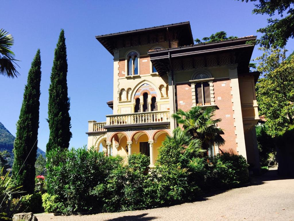 un grande edificio con alberi di fronte di Villa Castiglioni Apartment a Laglio