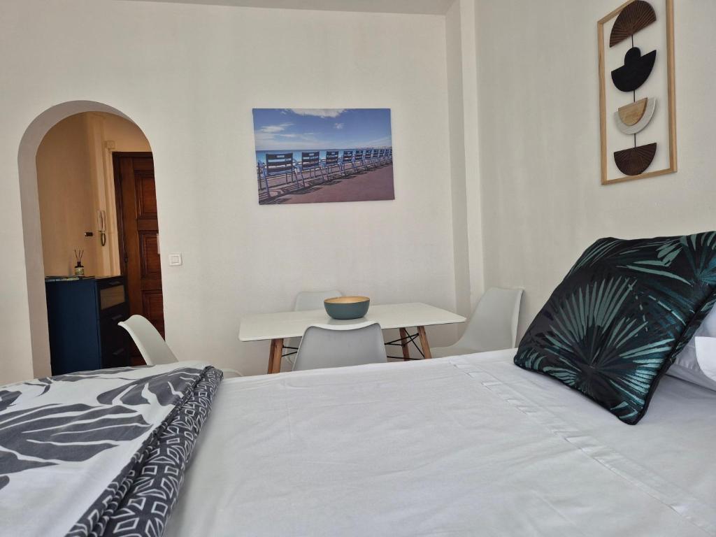 - une chambre avec un lit et une table à manger dans l'établissement Le Grand Sud, à Nice