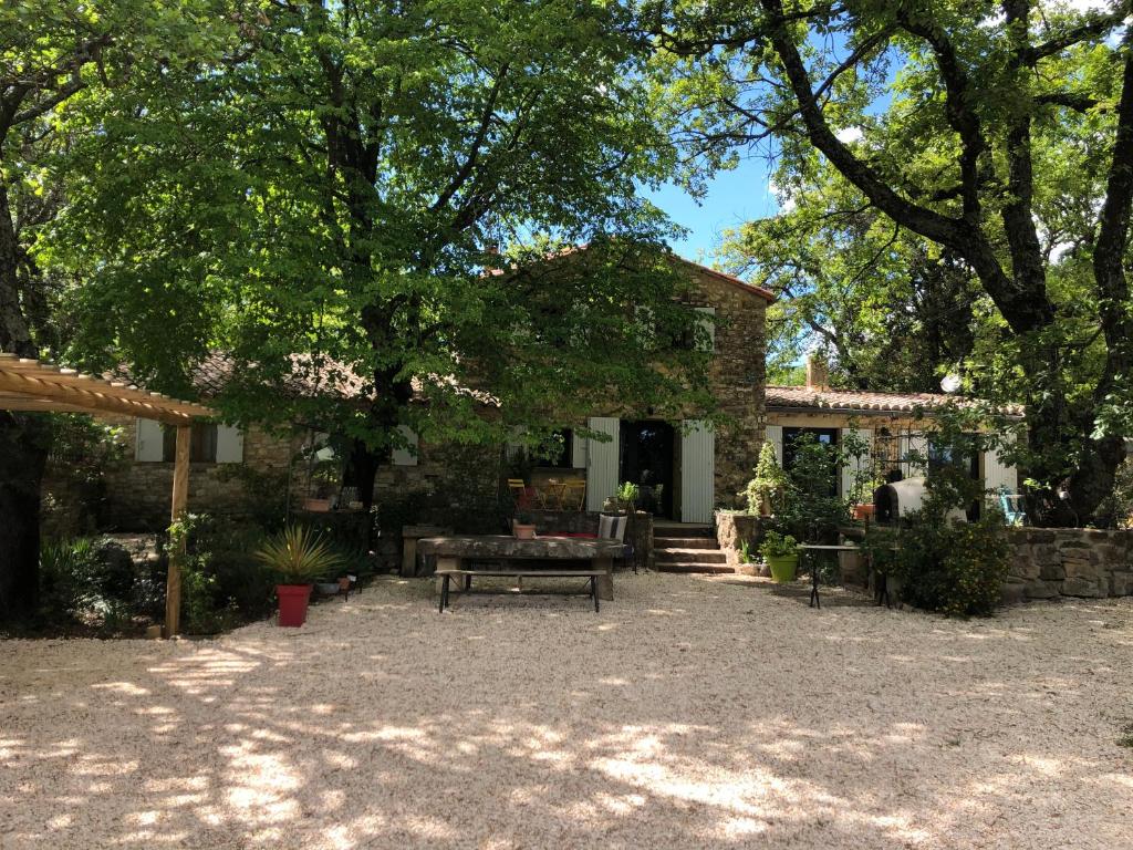 une maison avec un banc devant dans l'établissement Le petit Mas, à Arpaillargues-et-Aureillac