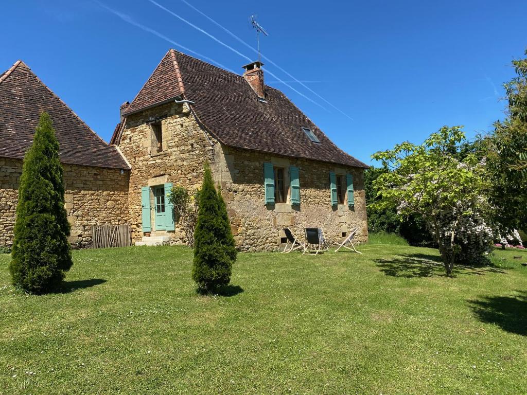 an old stone house on a green lawn at Petite maison rurale in Anlhiac