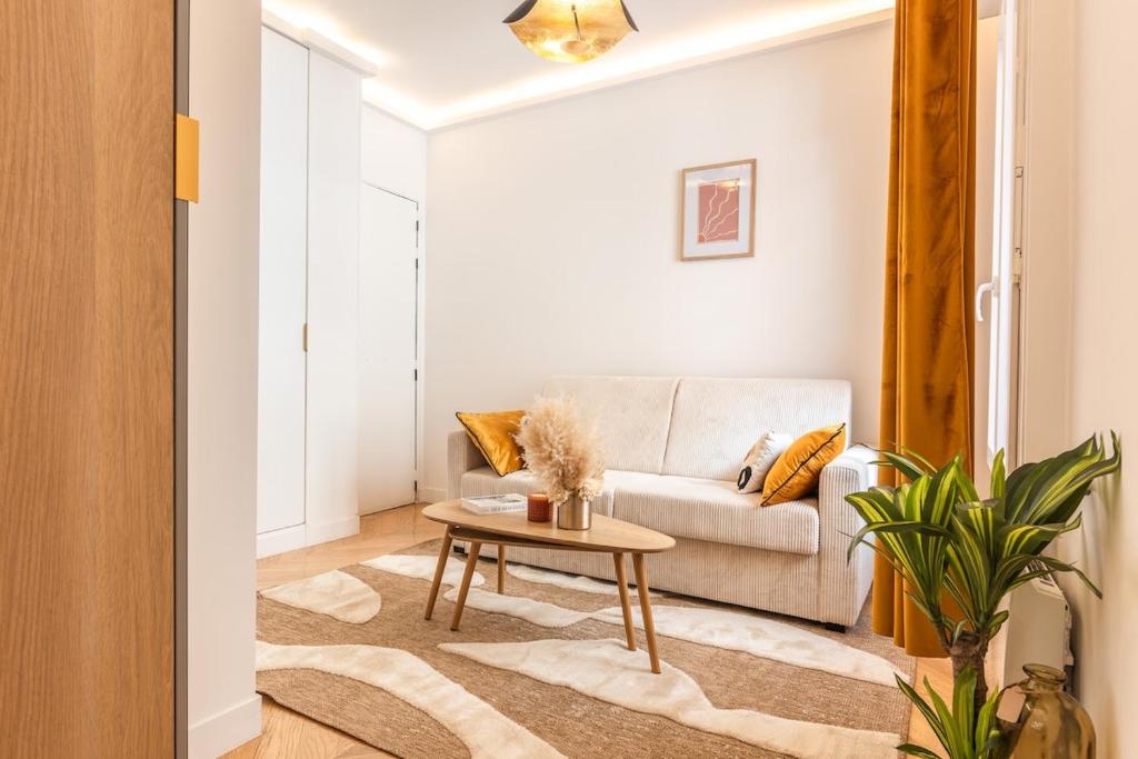 un salon avec un canapé et une table dans l'établissement Appartement Raffiné avec Jacuzzi et AC - 6P, à Paris