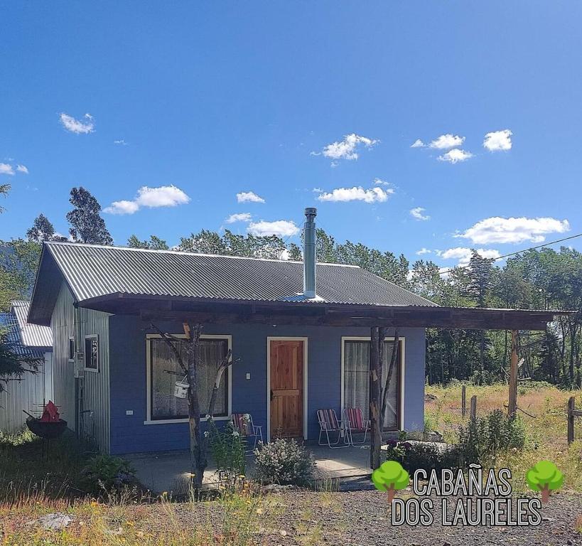 una piccola casa blu con un tetto di Cabañas Dos Laureles a Coñaripe