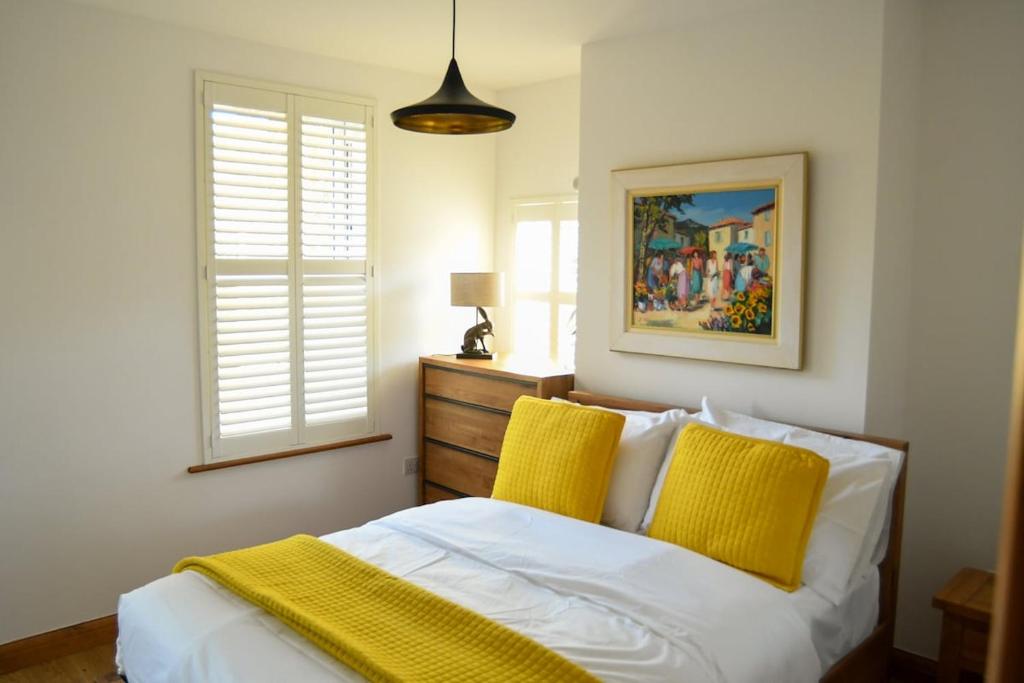 a bedroom with a bed with two yellow pillows at Foundry View in Millom
