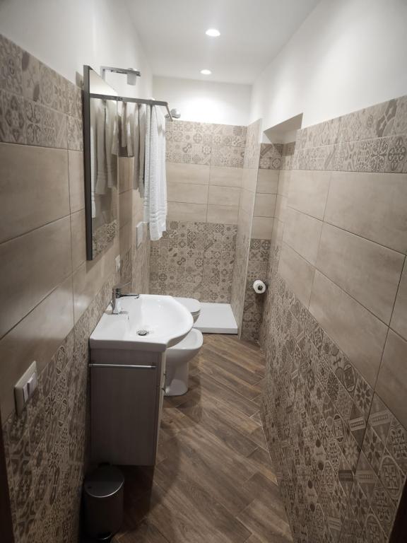 a bathroom with a sink and a toilet at Palazzo Grecale Dell'Etna in Aci SantʼAntonio