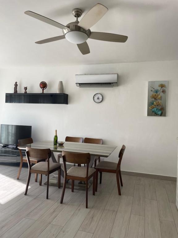a dining room with a ceiling fan and a table and chairs at Luxury sea Cadaques Caribe in Bayahibe