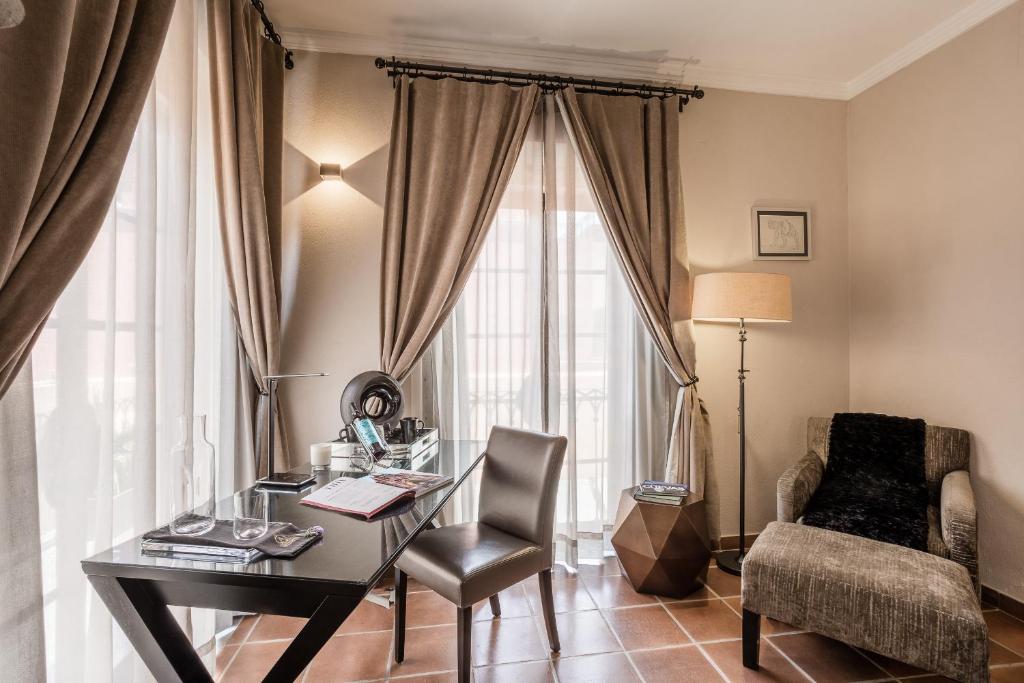 a desk and chair in a room with a window at Artesana - Privately Owned Rosewood Residence in San Miguel de Allende