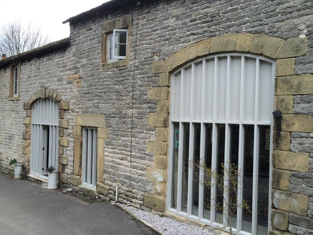 un edificio de ladrillo con puertas y ventanas blancas en Haddock Hideaway, en Castleton